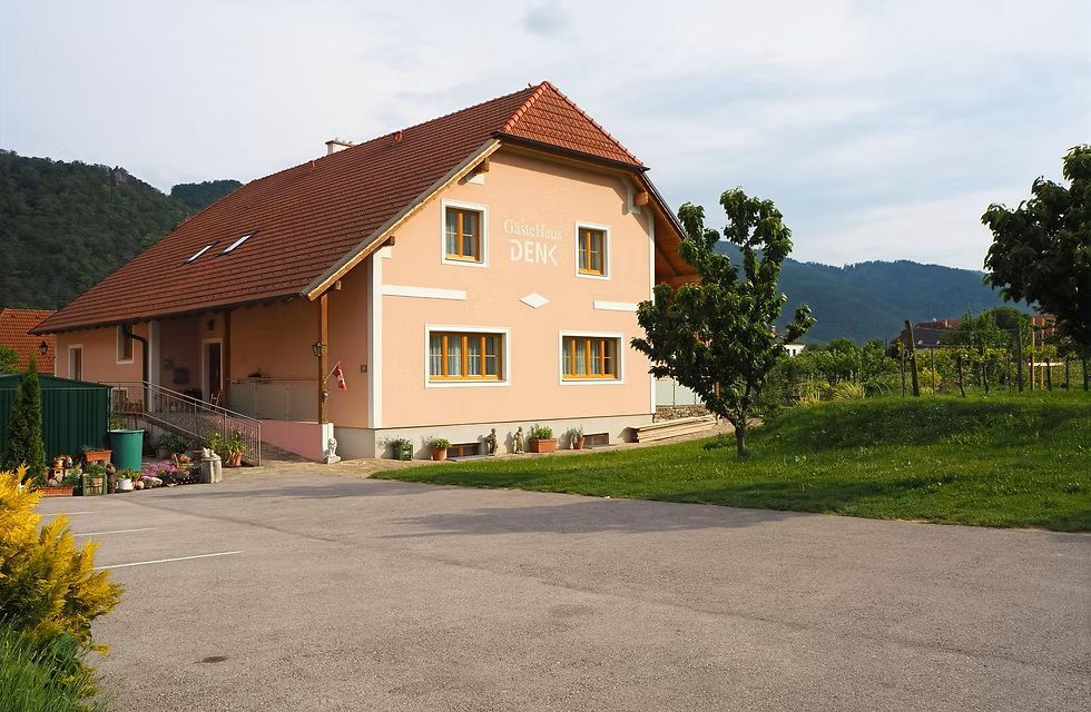 orange detached house with asphalted parking area in front of it