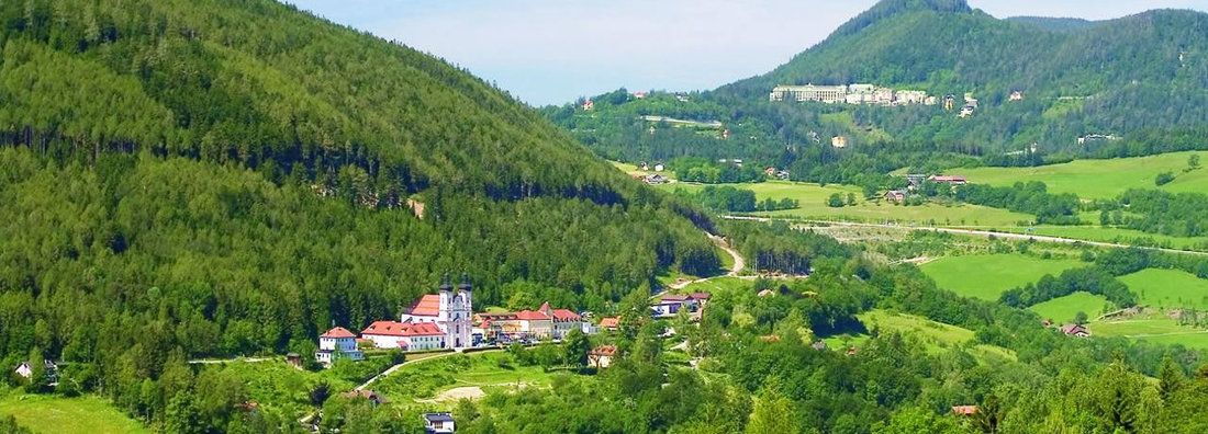 Landscape with church and green hills in the foreground.