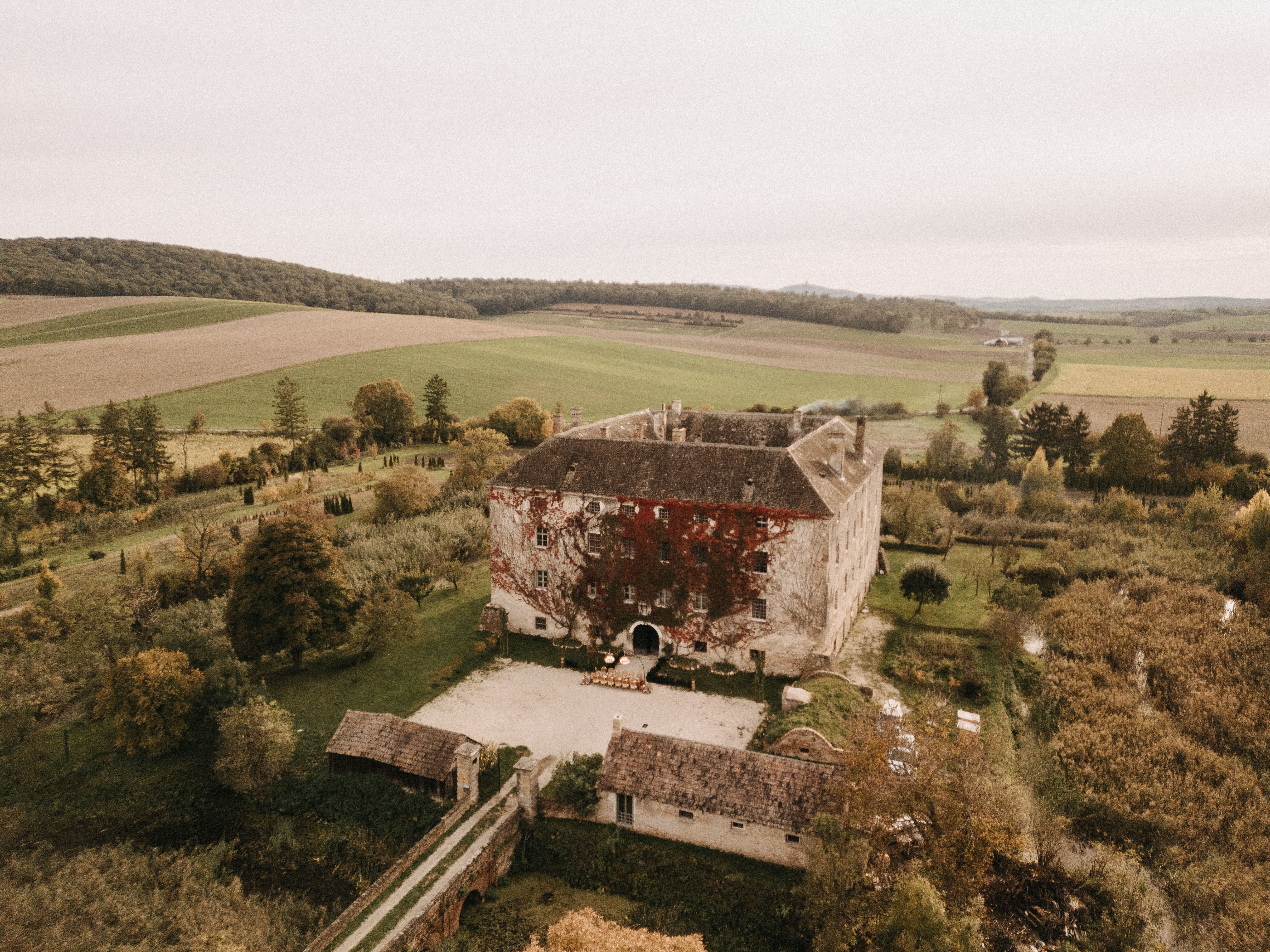 Aerial view of Haggenberg Castle surrounded by fields and trees.