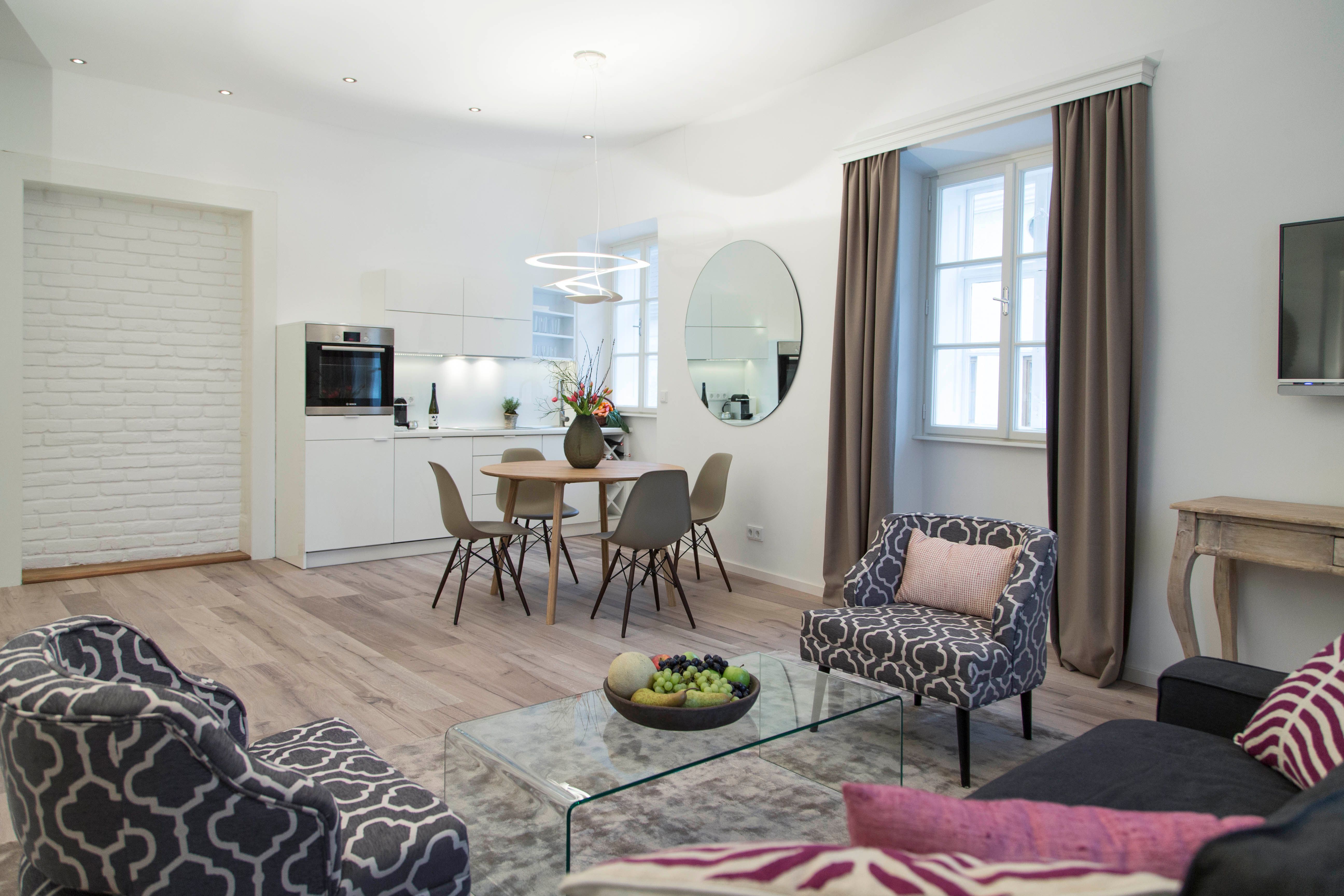 Modern living room with kitchen, dining table and stylish furniture.