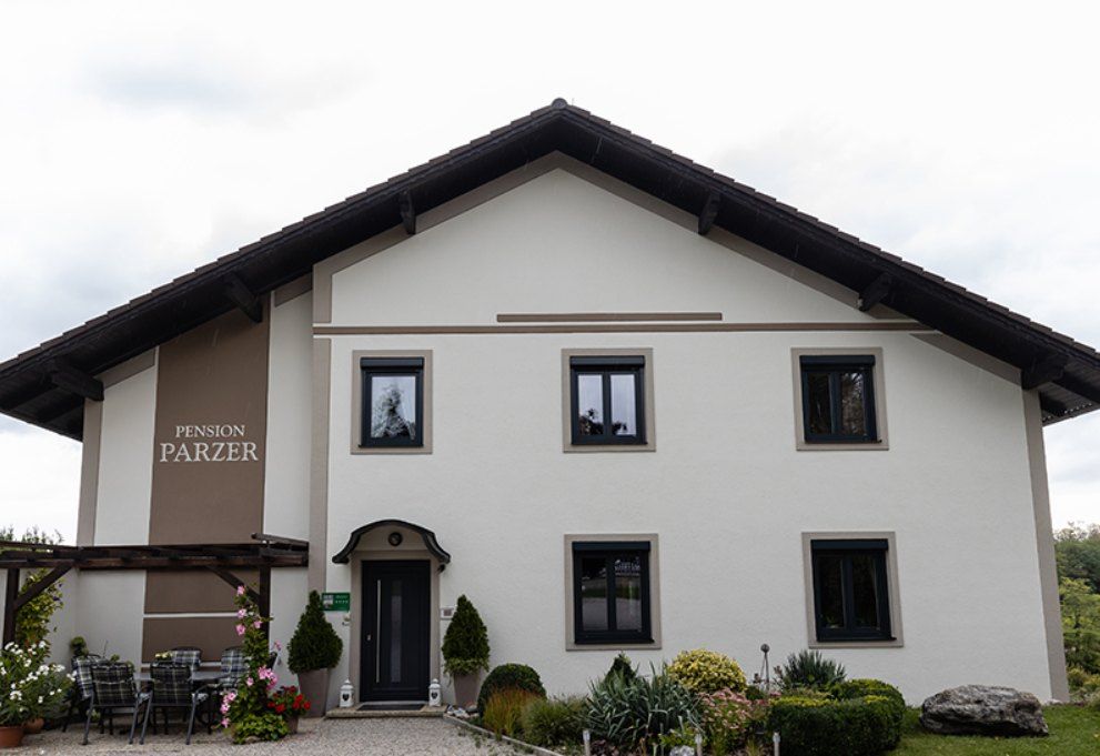 Exterior view of Pension Parzer with garden and terrace.
