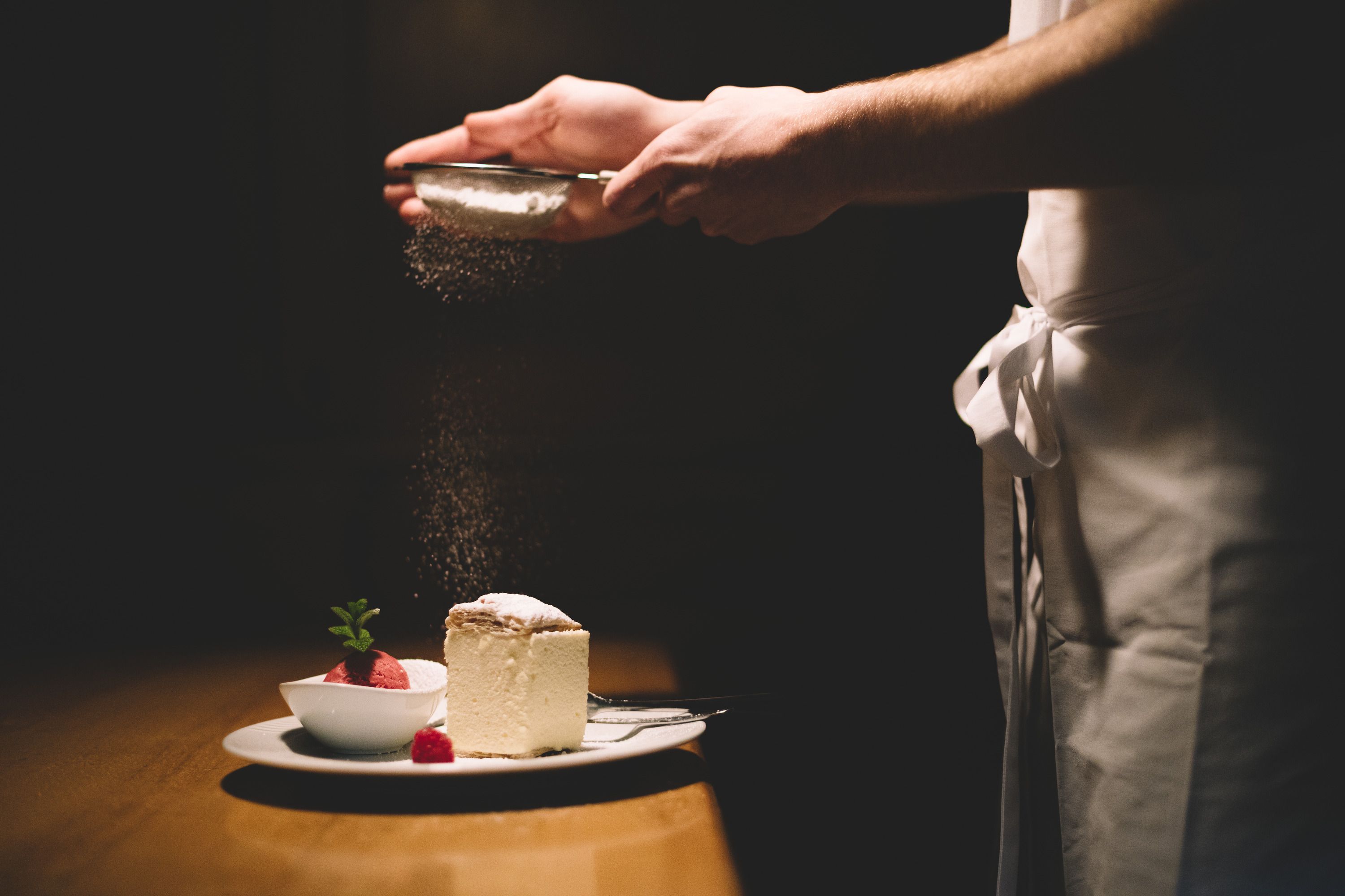 A plate with cream slice and raspberry sorbet, sprinkled with powdered sugar.