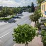 Street scene with yellow building and parking lot, trees and cars.