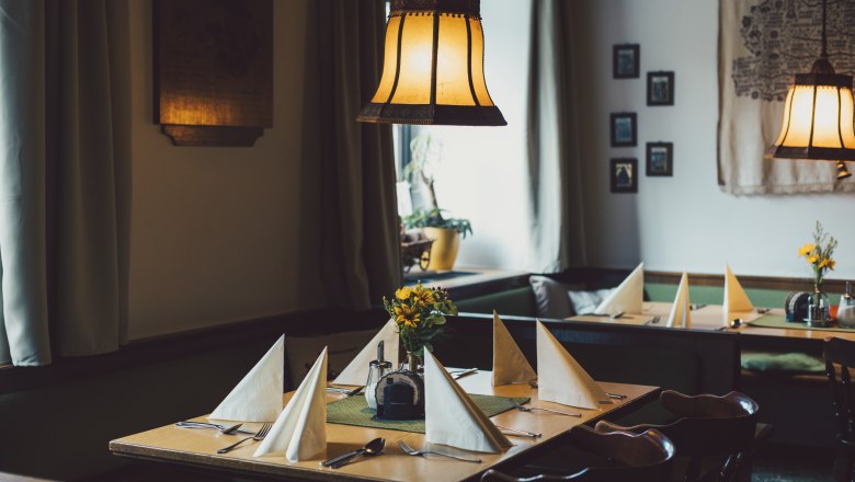 Cozy, traditionally furnished parlor with set tables and warm light.