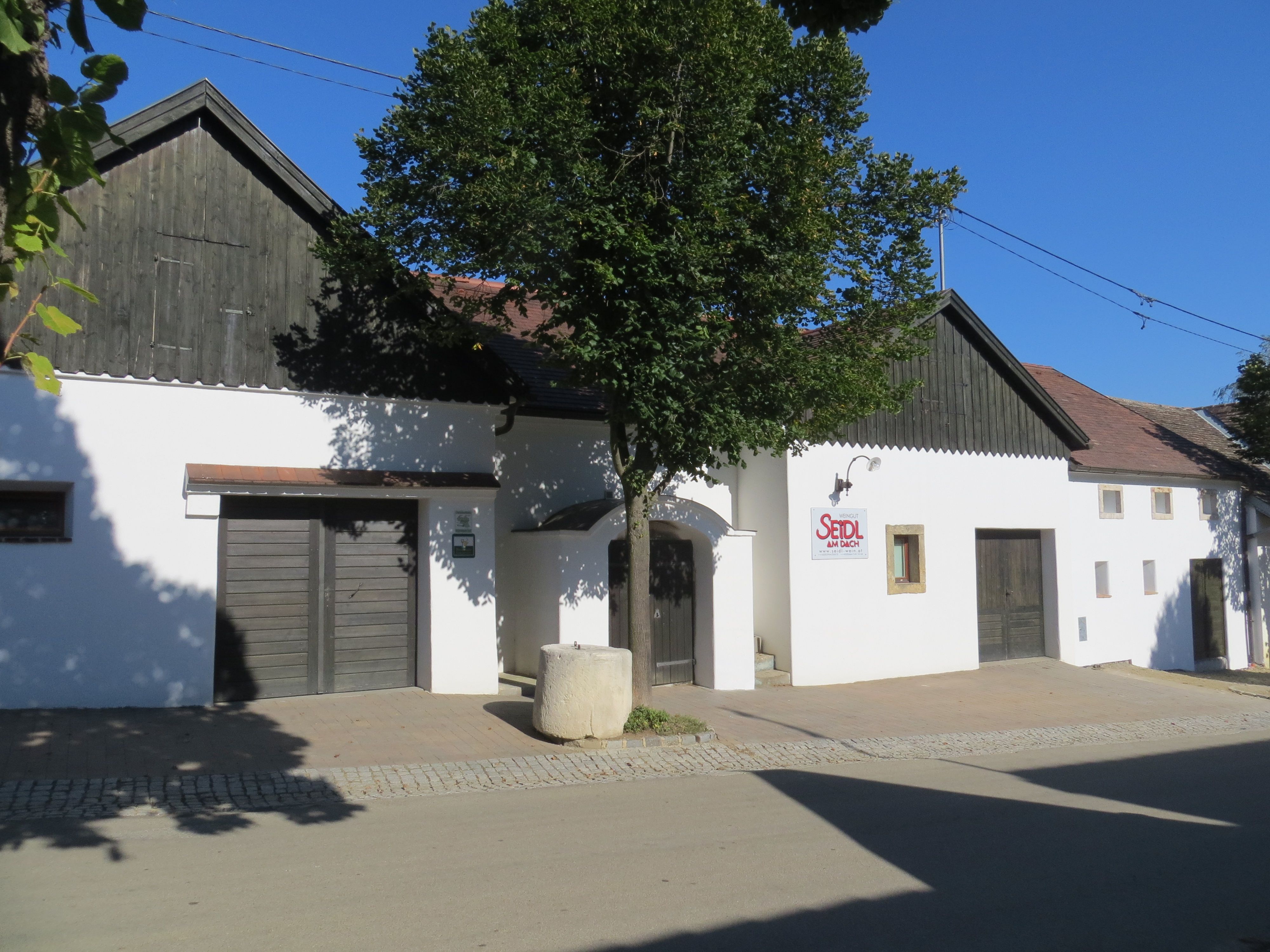 White building with wooden cladding and 'Seidl am Dach' sign.