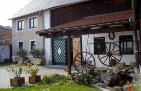 Traditional building with wooden roof and decorative wagon wheels in the courtyard.
