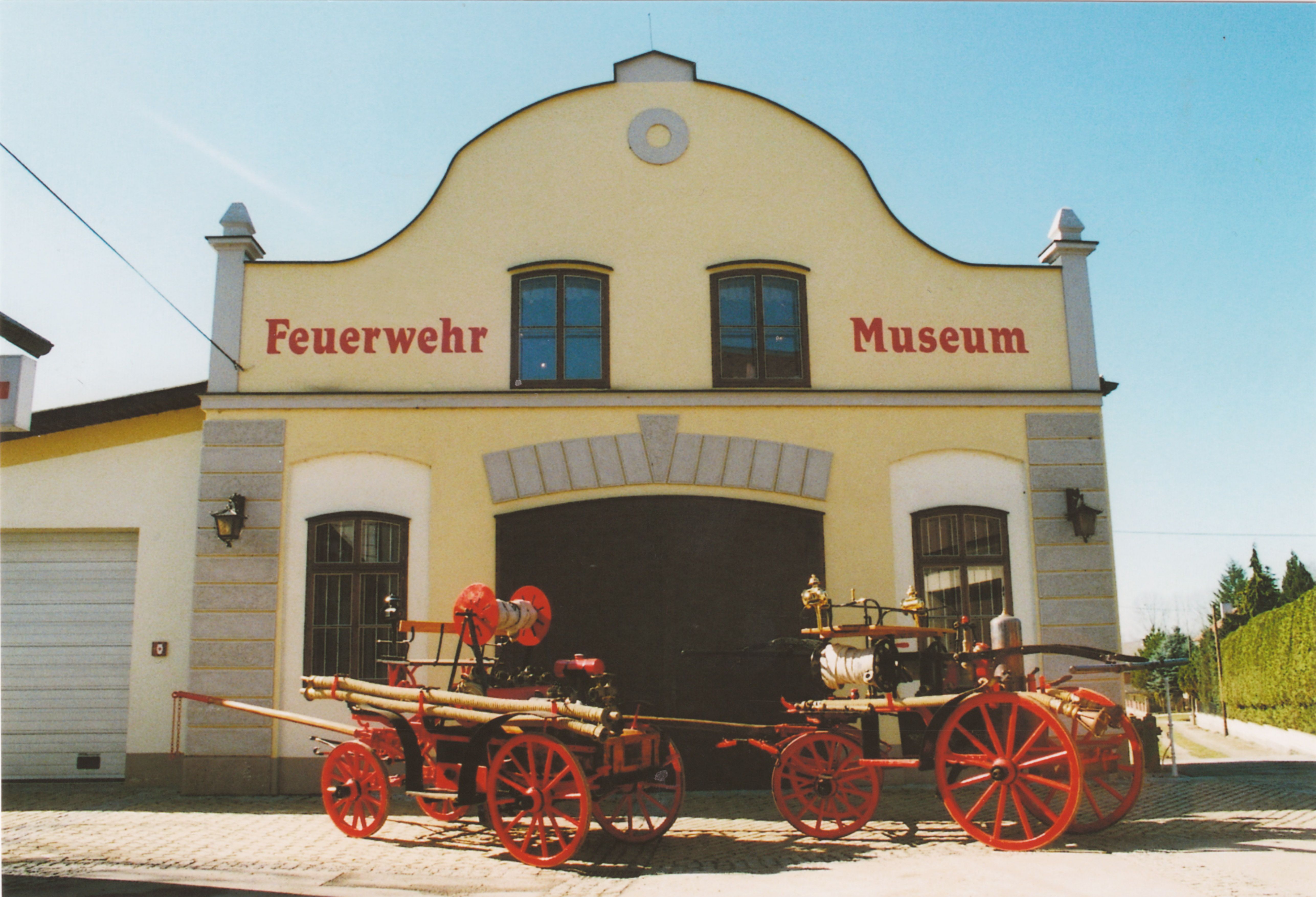 Historic fire engines in front of the St. Leonhard am Forst Fire Brigade Museum.