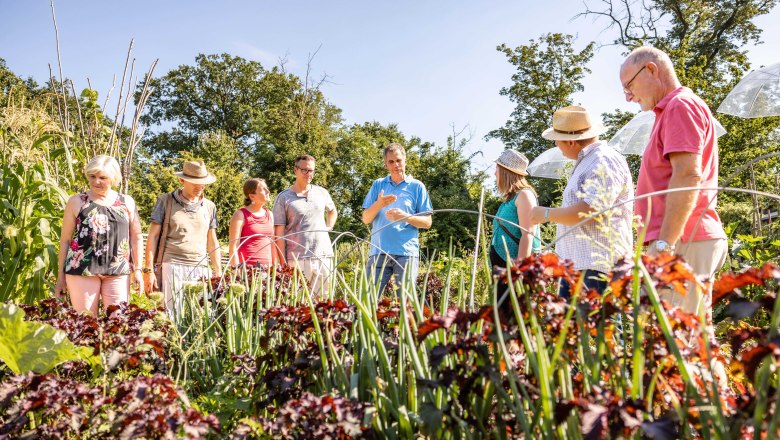 Group of people in front of a flower bed