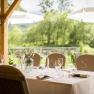 Outdoor table with a view of a pond and trees.