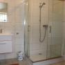 Modern bathroom with shower, washbasin and mirror.