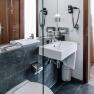 Modern hotel bathroom with washbasin, mirror and towels.