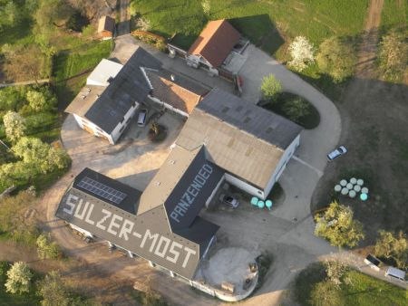 Aerial view of a building complex with the inscription 'Sulzer-Cider' on the roof.