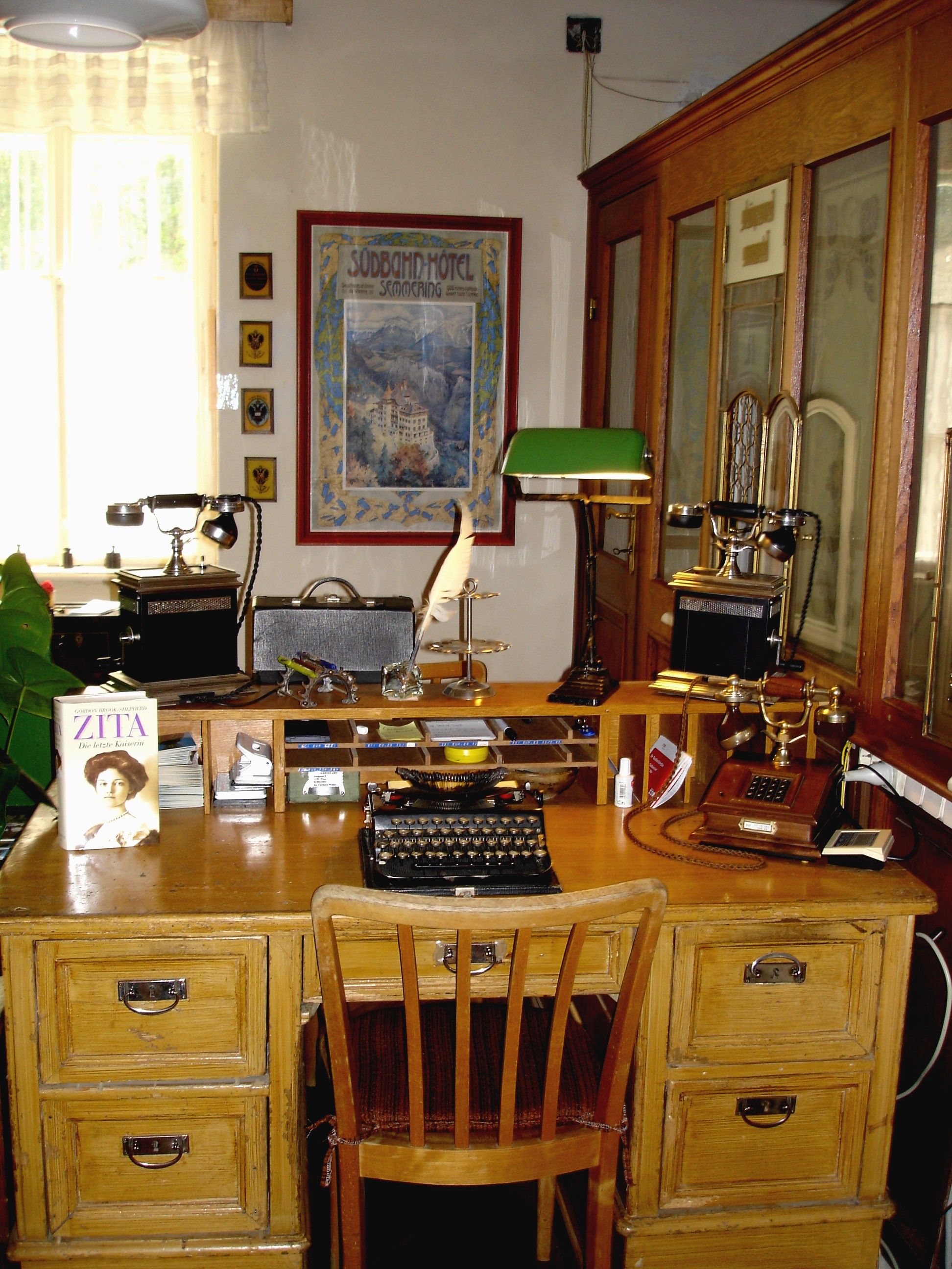 Historic desk with typewriter, telephone and books in a post office.