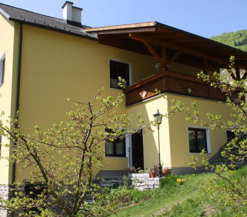 View of the Bergkirchner vacation apartment, © Familie Bergkirchner Yellow house with flowering tree