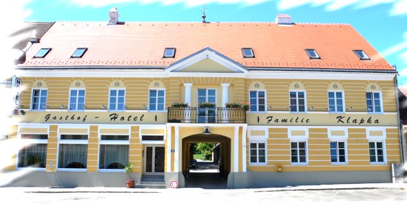Yellow building with red roof and lettering 'Gasthof-Hotel Familie Klapka'.