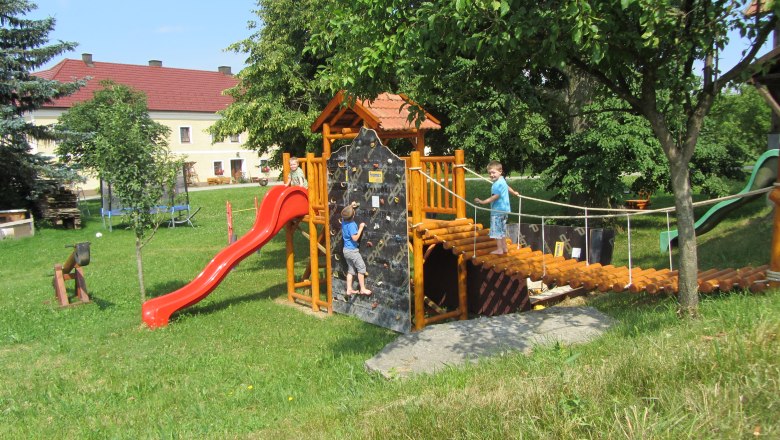 Playground with climbing frame, slide and two children playing.