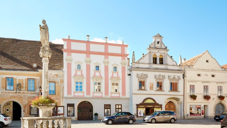 Historic buildings on Eggenburg's main square with a statue in the foreground.
