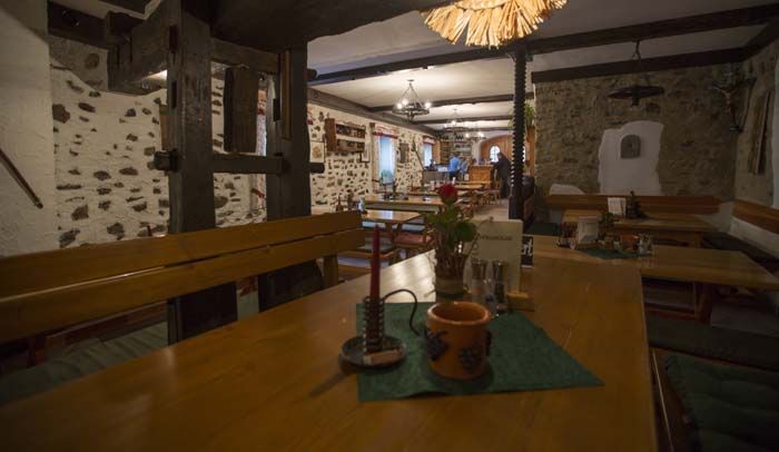 Rustic restaurant with wooden tables and stone walls.