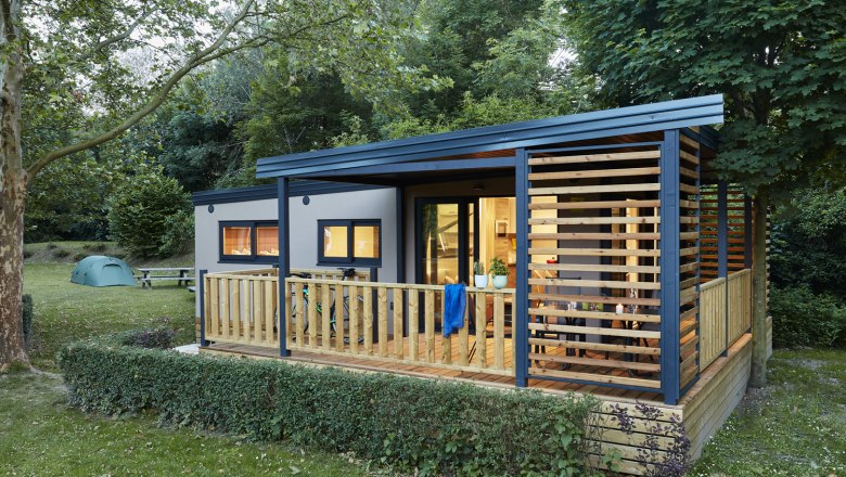 Mobile home exterior, © Camping Tulln Mobile home from the outside with a view of the terrace and illuminated rooms