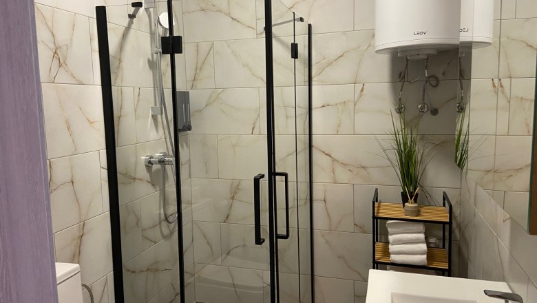 Modern bathroom with shower cubicle, washbasin and towel rack.