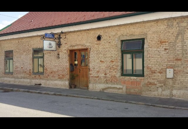 Exterior view of an old inn with tiled roof and brick fa&ccedil;ade.