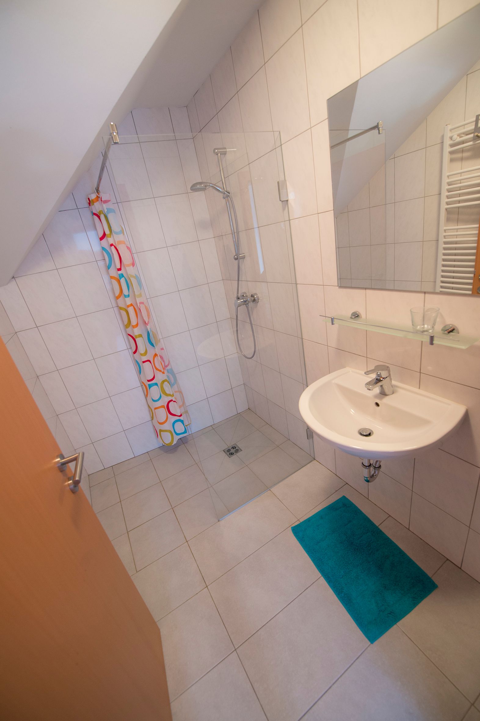 Bathroom with shower and washbasin with large mirror.