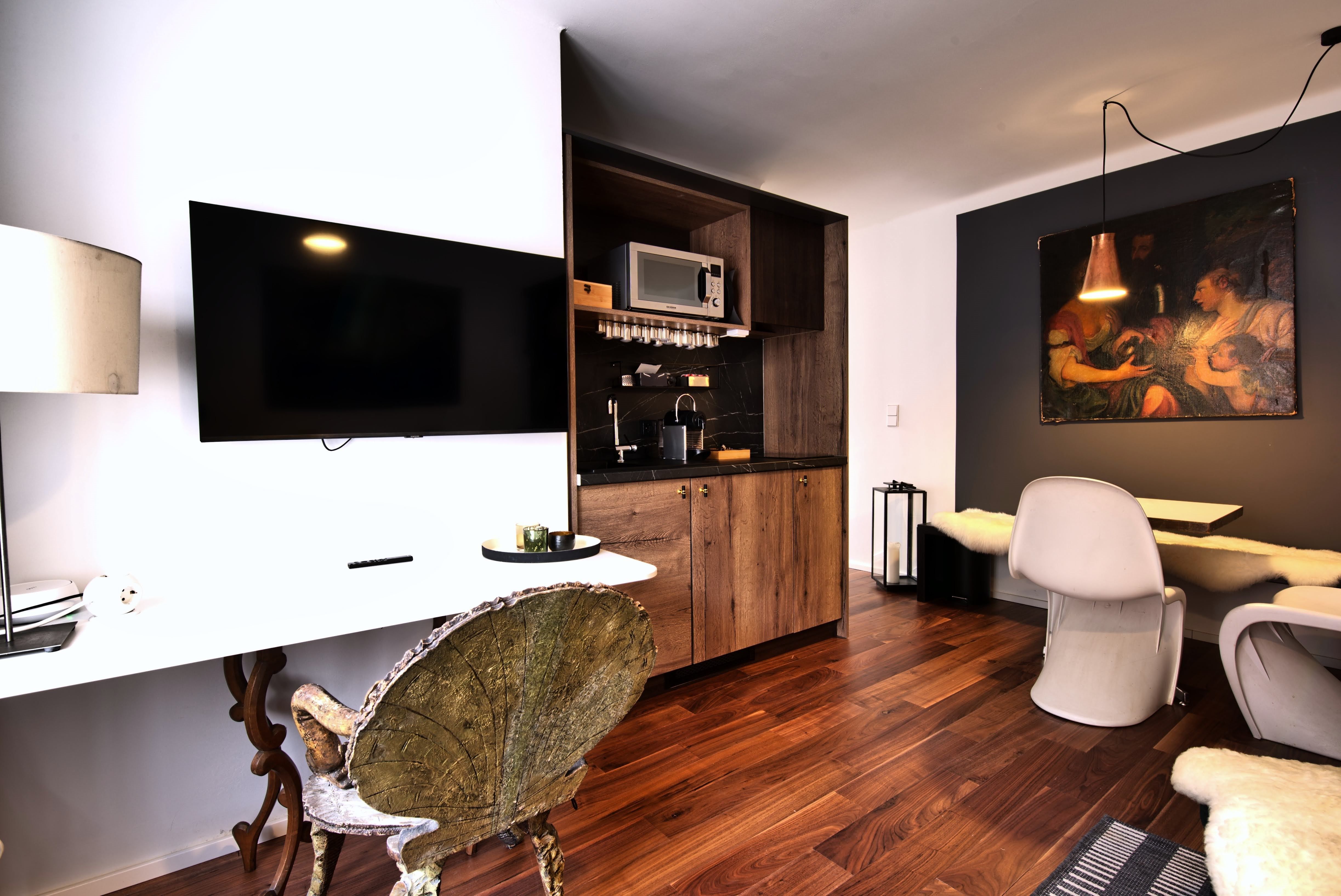Modern kitchen with wooden elements, flat screen TV and dining area.