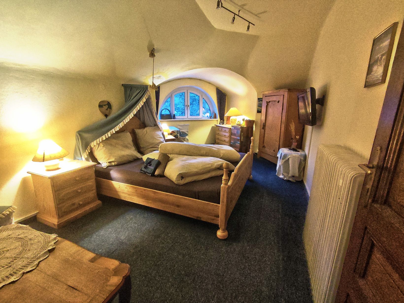 Cozy bedroom with wooden furniture and vaulted ceiling.
