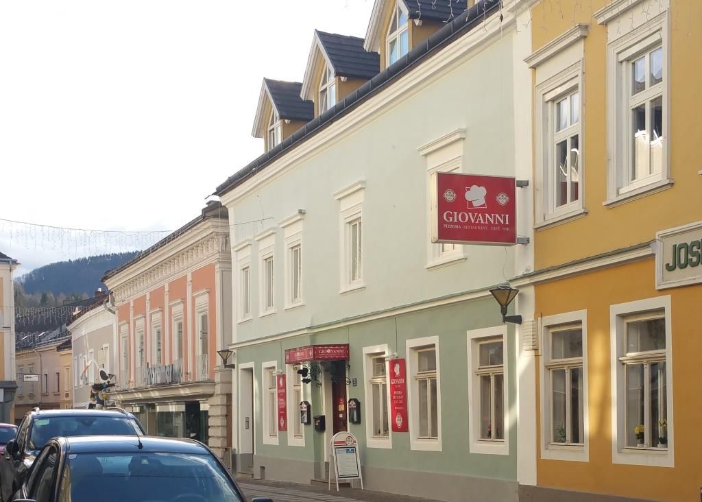 Street scene with colorful buildings and a sign with the inscription 'Giovanni'.