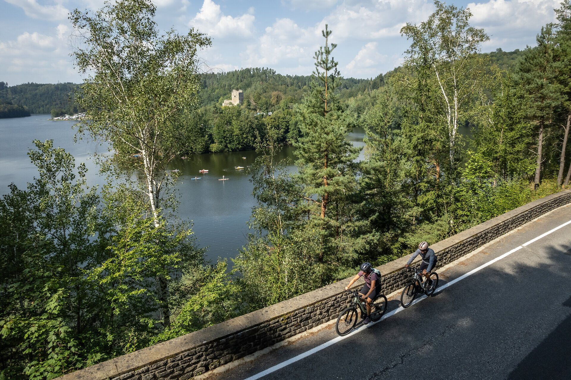 Cyclists glide along the picturesque Kamp Valley ("Kamptal" in German) cycle path, surrounded by lush greenery and sparkling water. The rolling hills in the background and the historic ruins of Dobra add a touch of romance and adventure to the scenery. Here, summer in the mountains becomes an unforgettable experience.