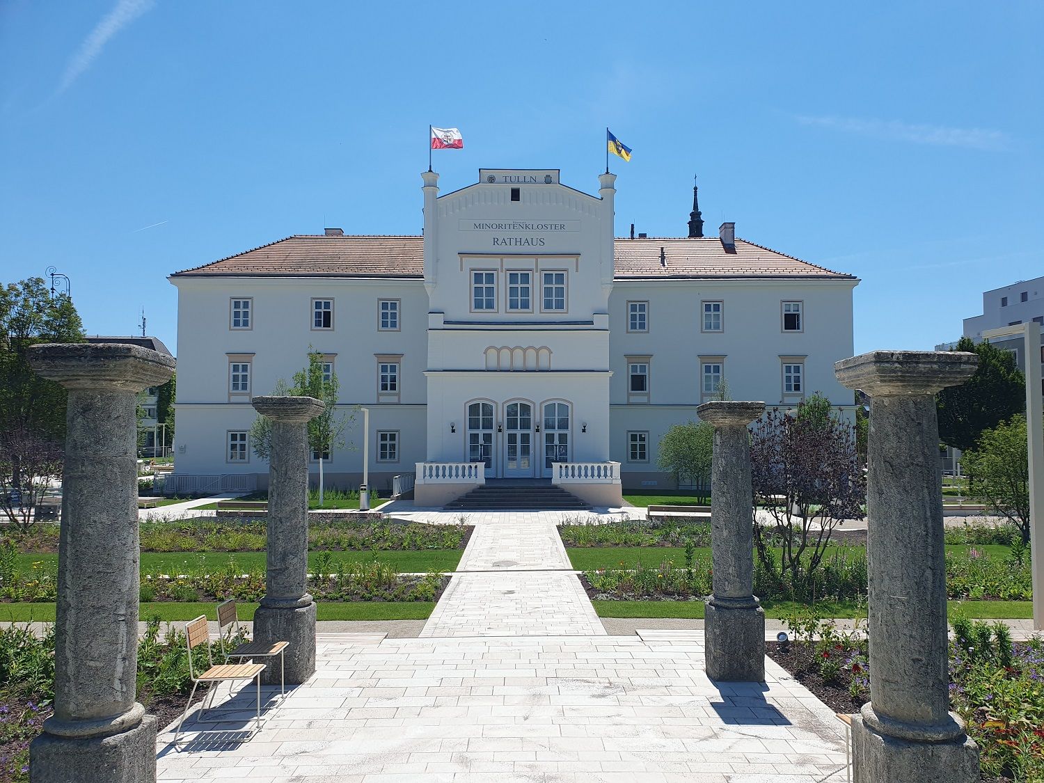 Town hall from the front with waving flags and path to the entrance 