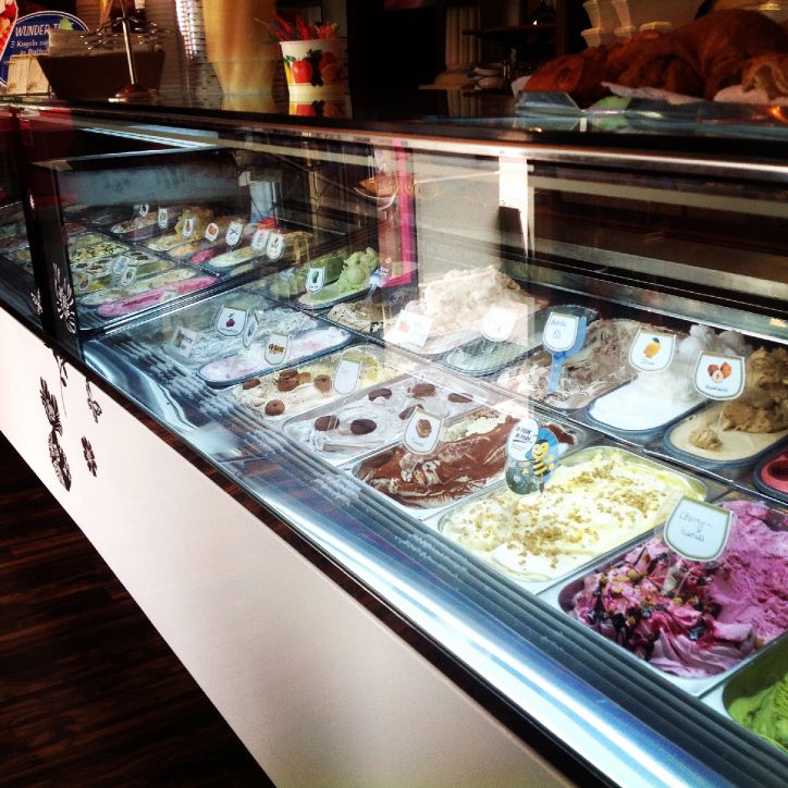 Ice cream display case with different types of ice cream in a café.