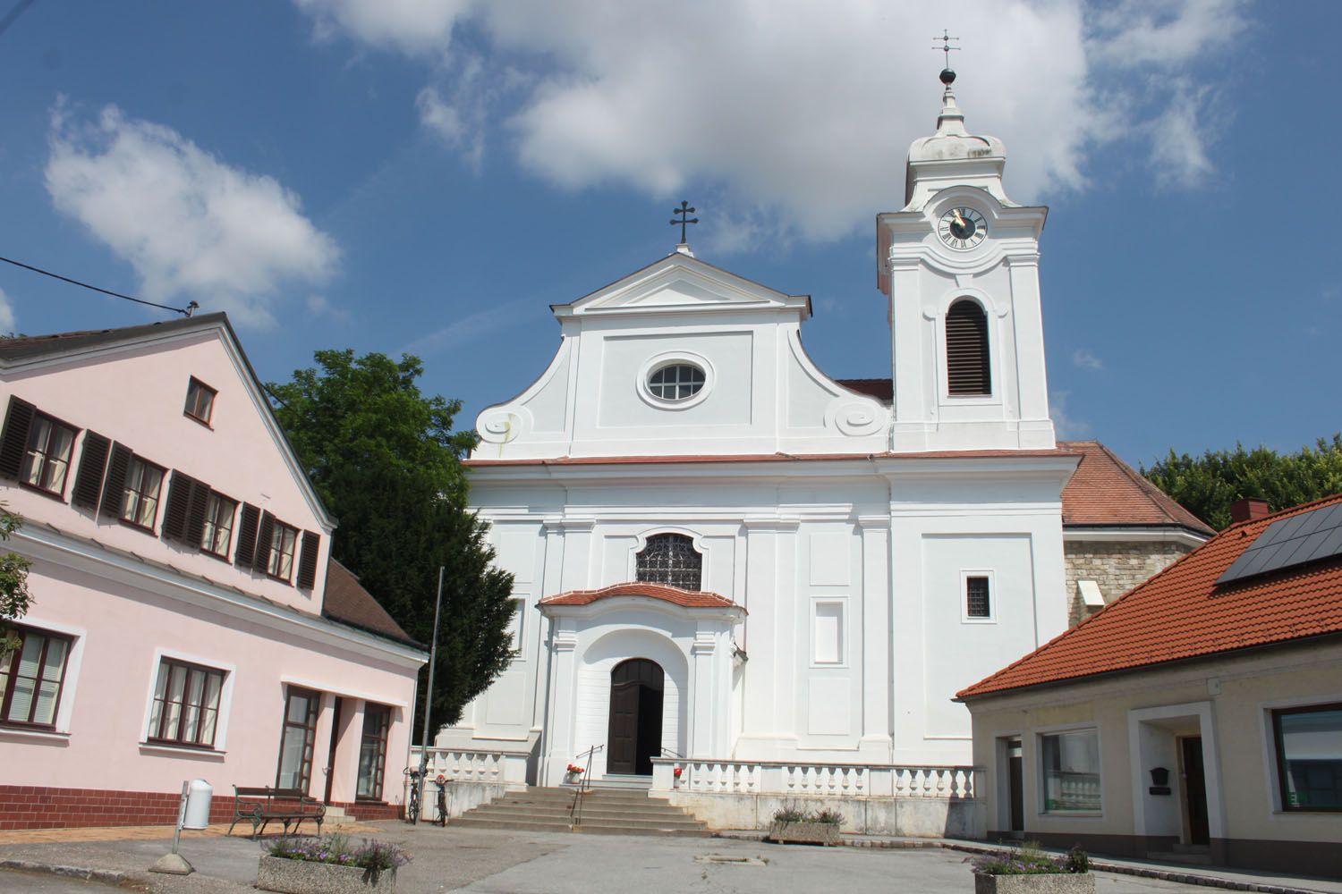 Wilfersdorf parish church with white façade and bell tower.