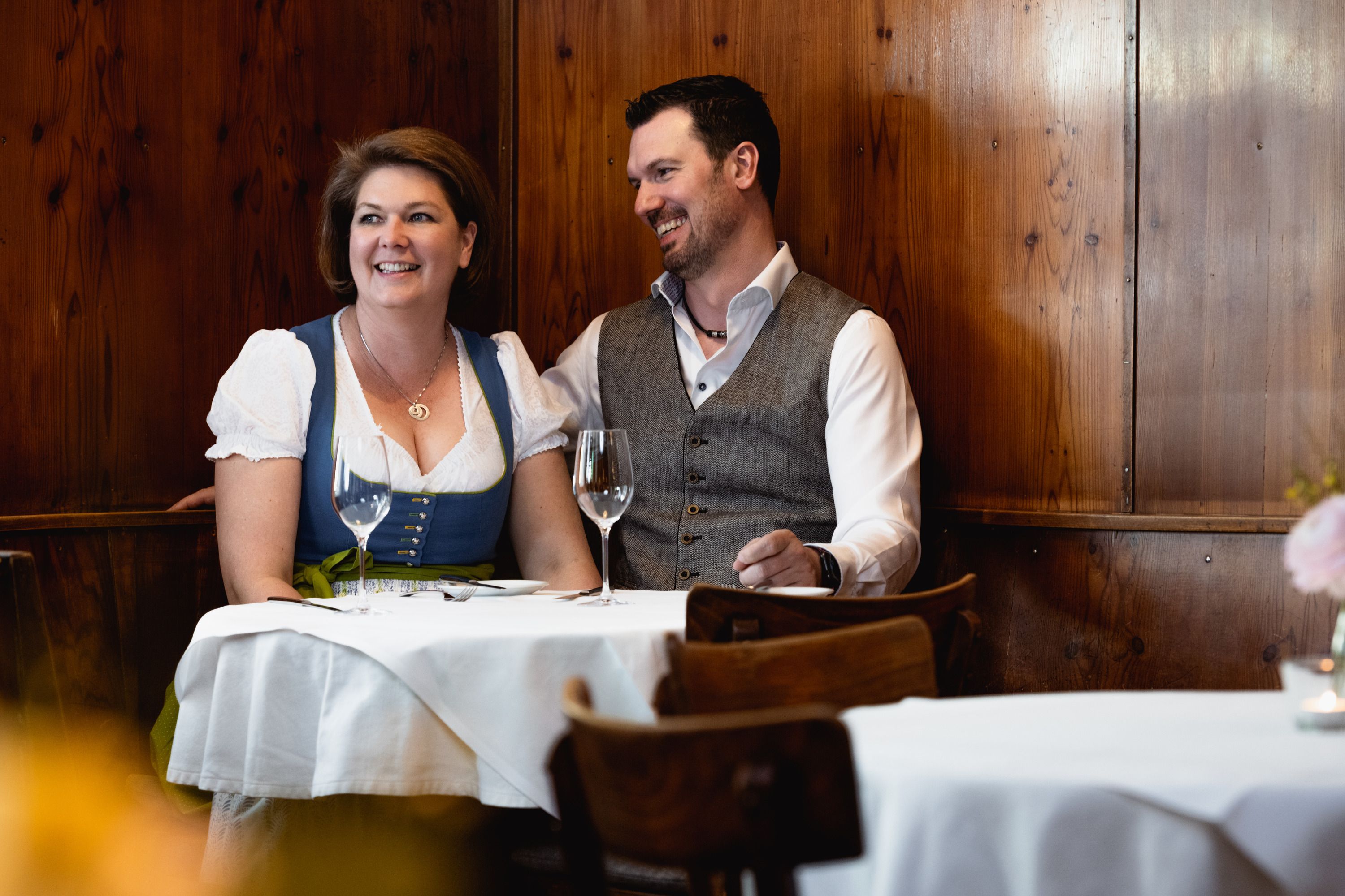 Smiling couple in traditional dress in a restaurant.
