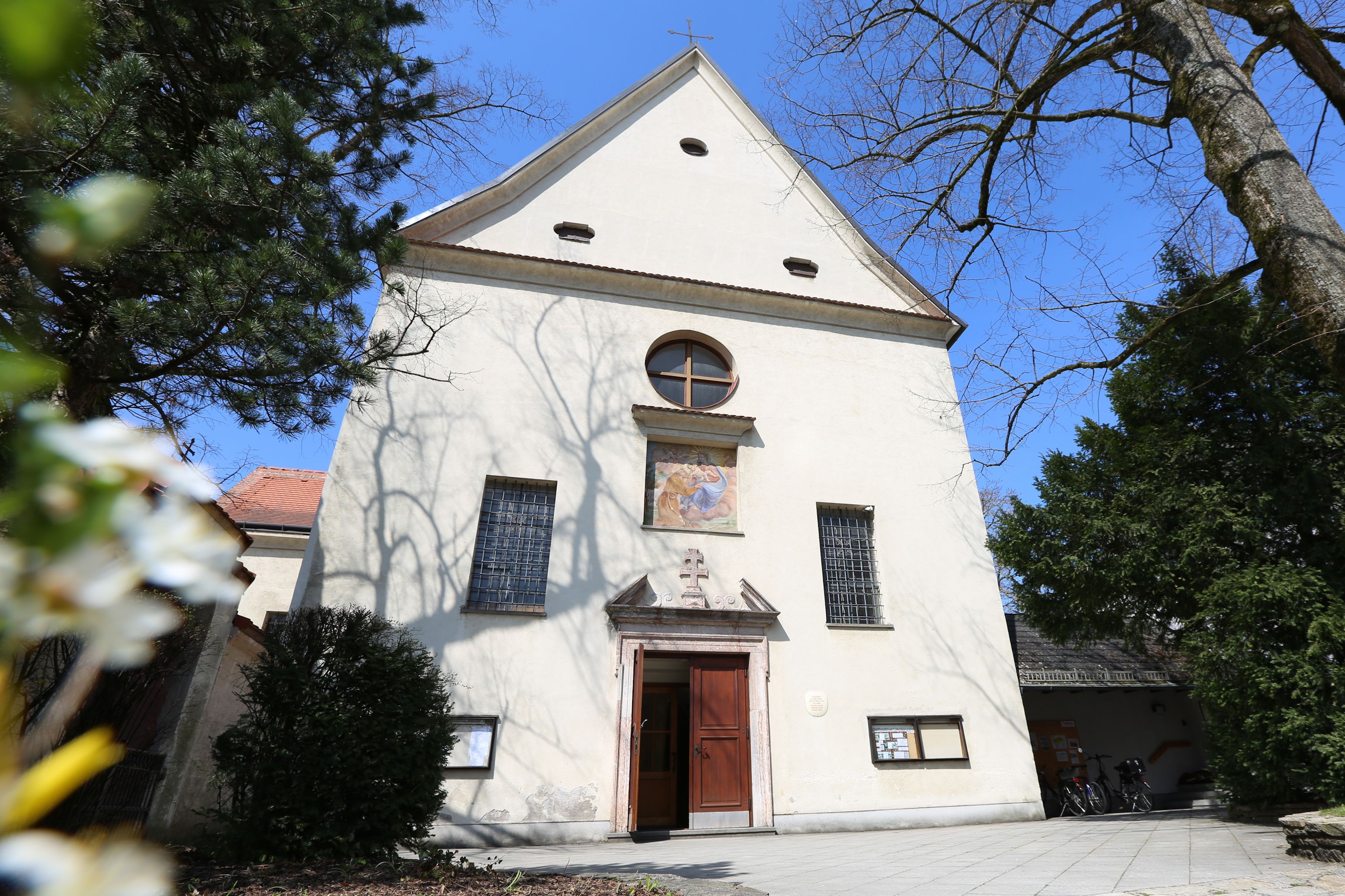 Facade of the Capuchin church with entrance and windows, surrounded by trees.