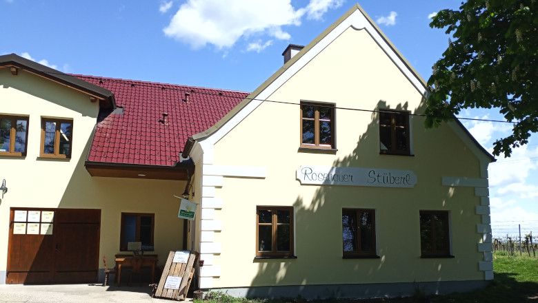 A yellow building with a red roof and the inscription 'Rosenauer Stüberl'.