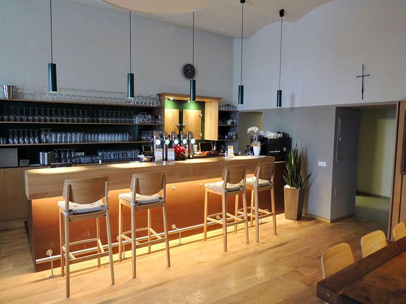 Interior view of a bar with wooden counter and bar stools.