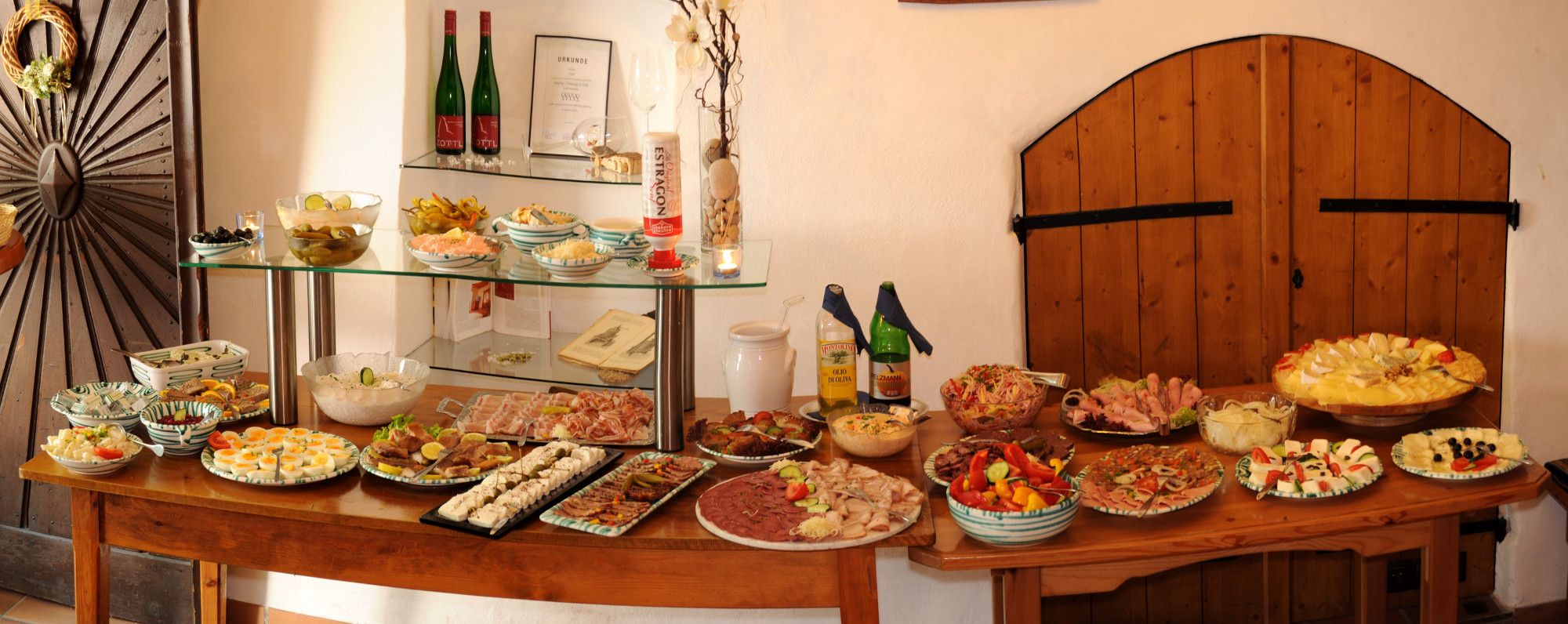 A buffet with various dishes and drinks on a wooden table.