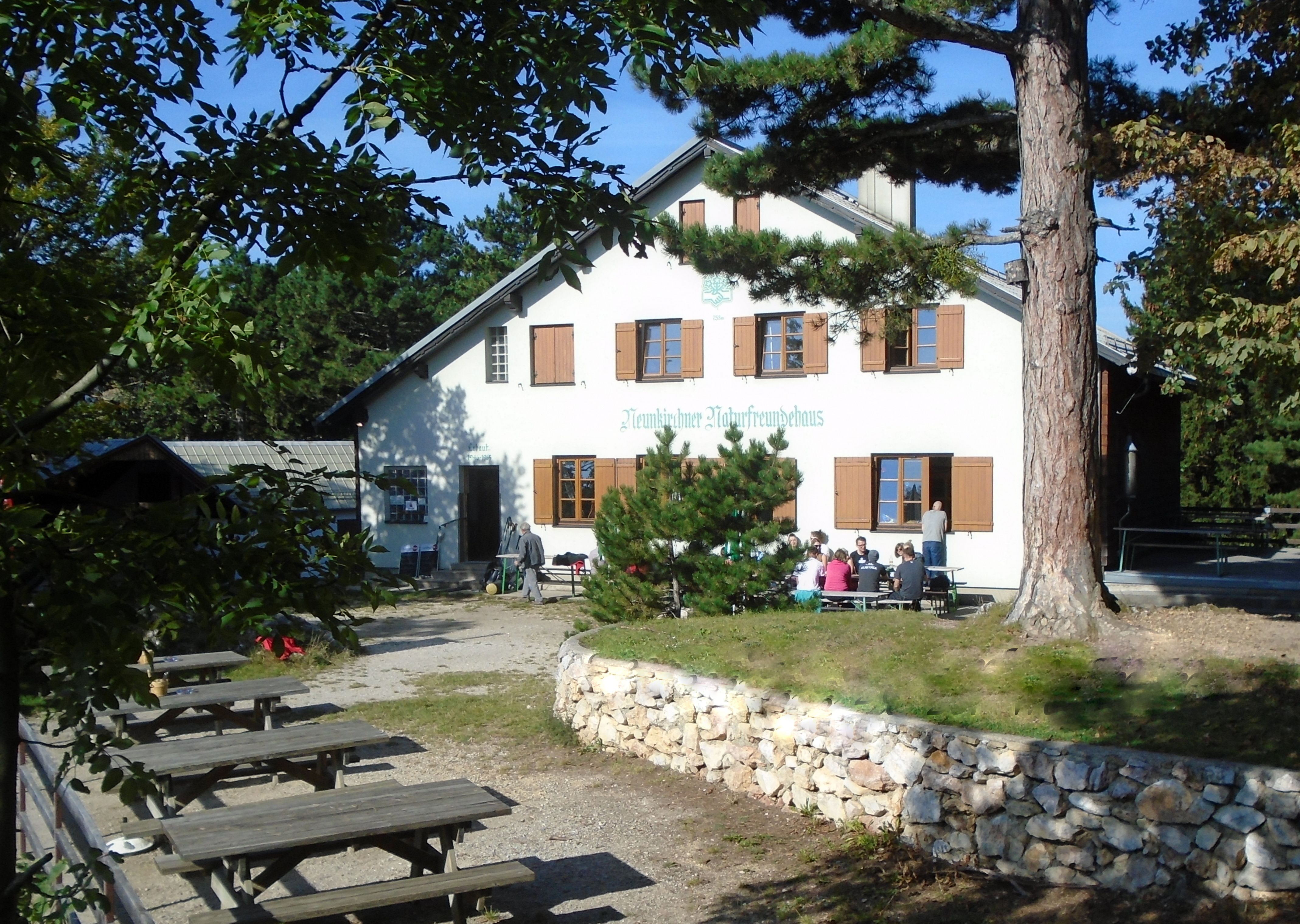 Exterior view of the Neunkirchen Naturfreundehaus with outdoor seating areas.