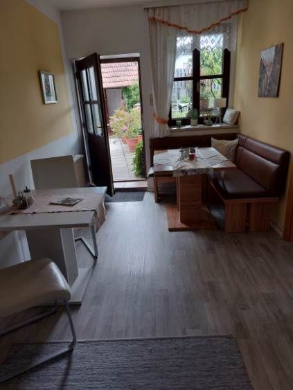 Cozy guest room with dining table, chairs and bench, view of the terrace.