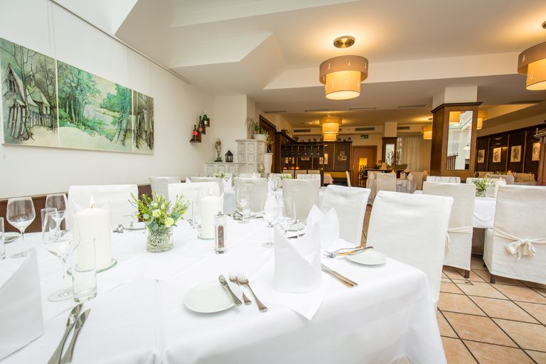 The winter garden with a set table and white chairs.