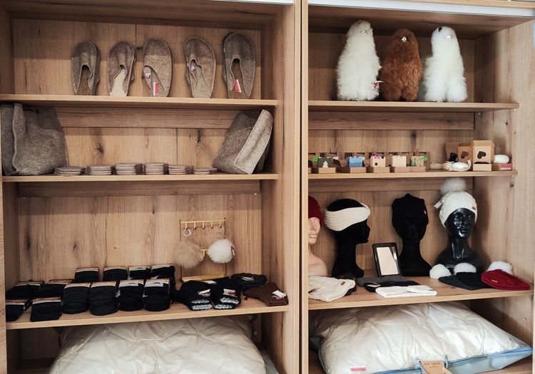 Shelves of felt slippers, hats, gloves and soft toys in a mobile farm store.