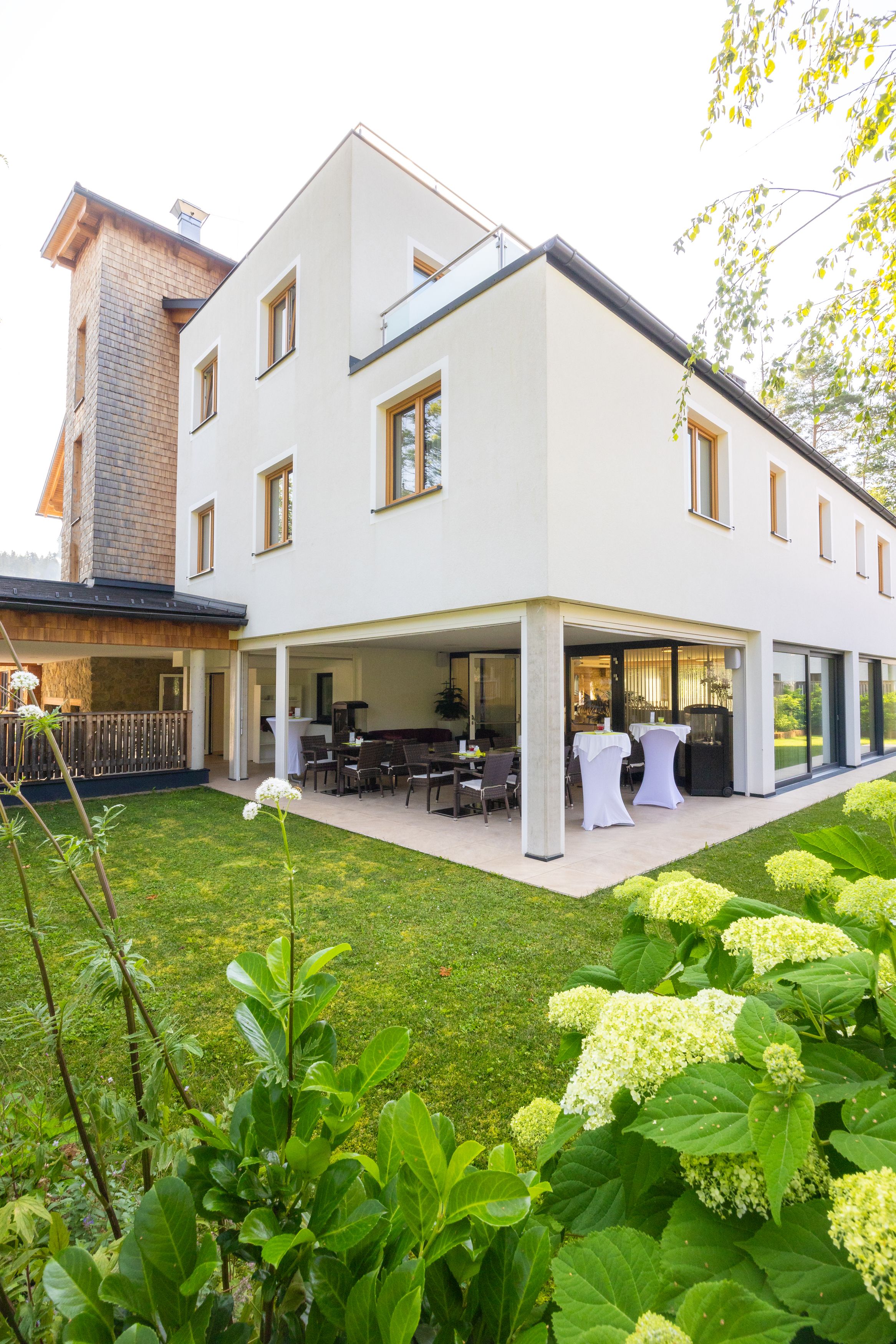 Exterior view of a modern hotel with terrace and garden.