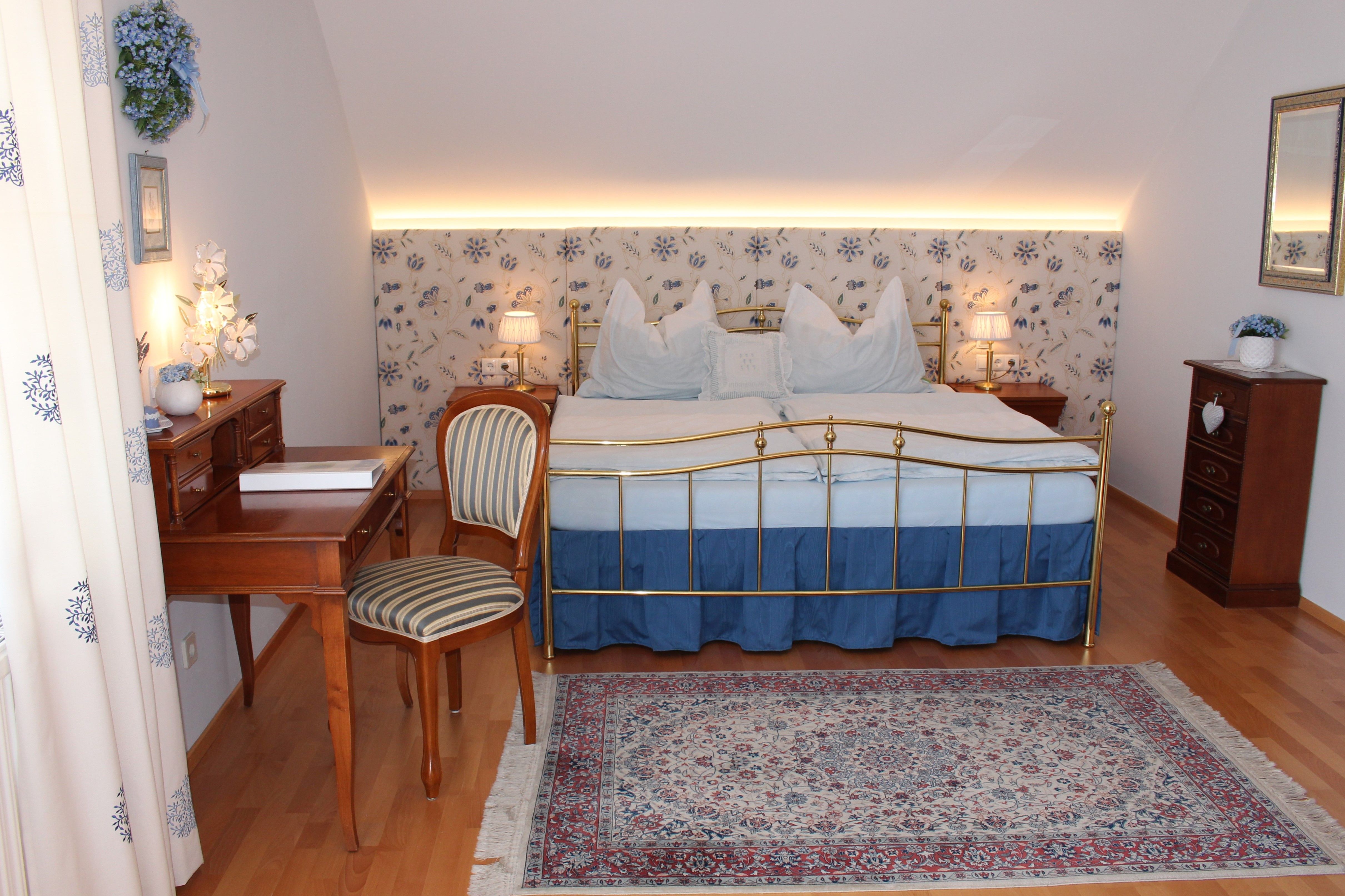 Comfortable bedroom with double bed, desk and carpet.