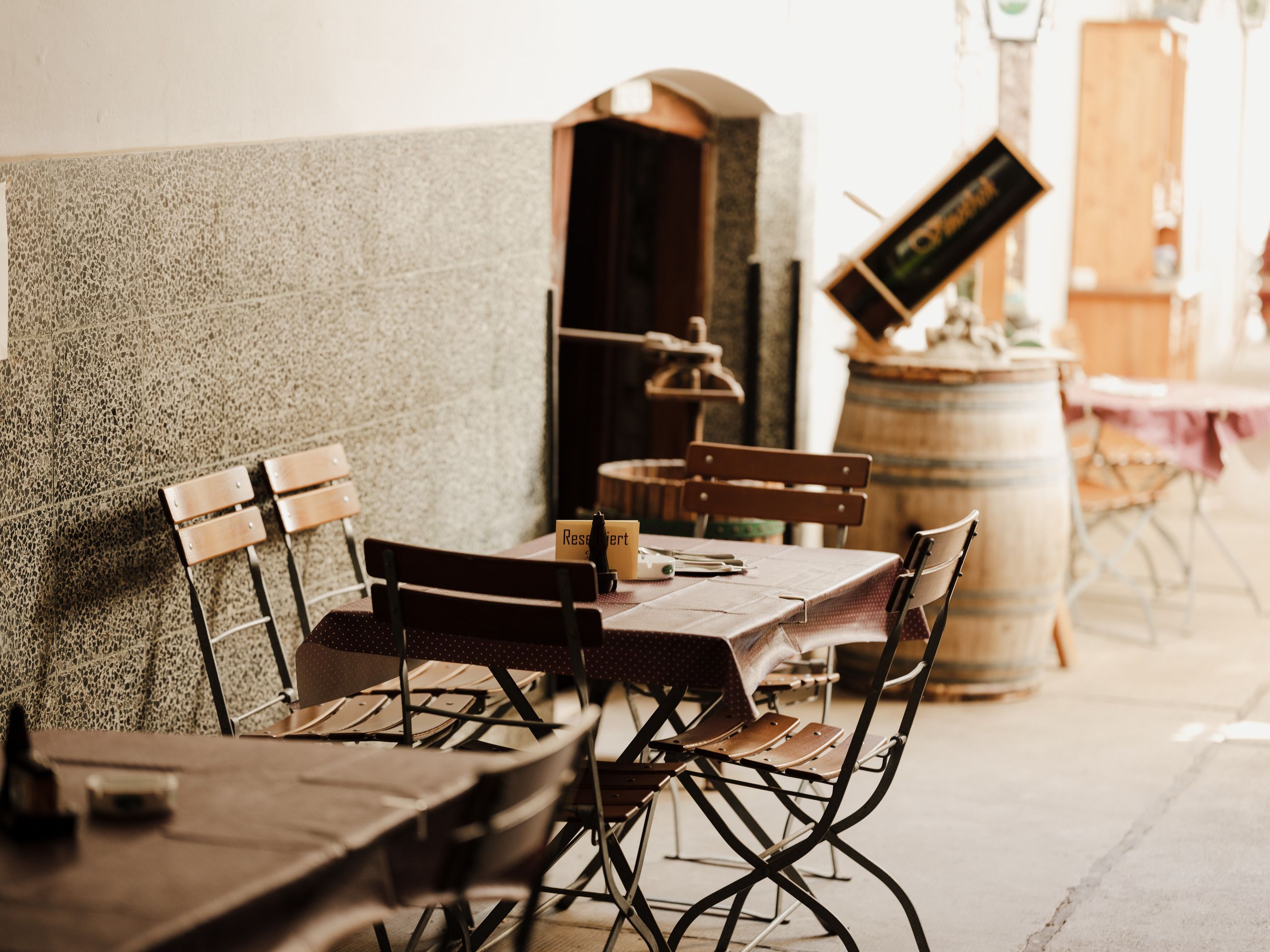 Cozy outdoor area of an inn with wooden tables and chairs.