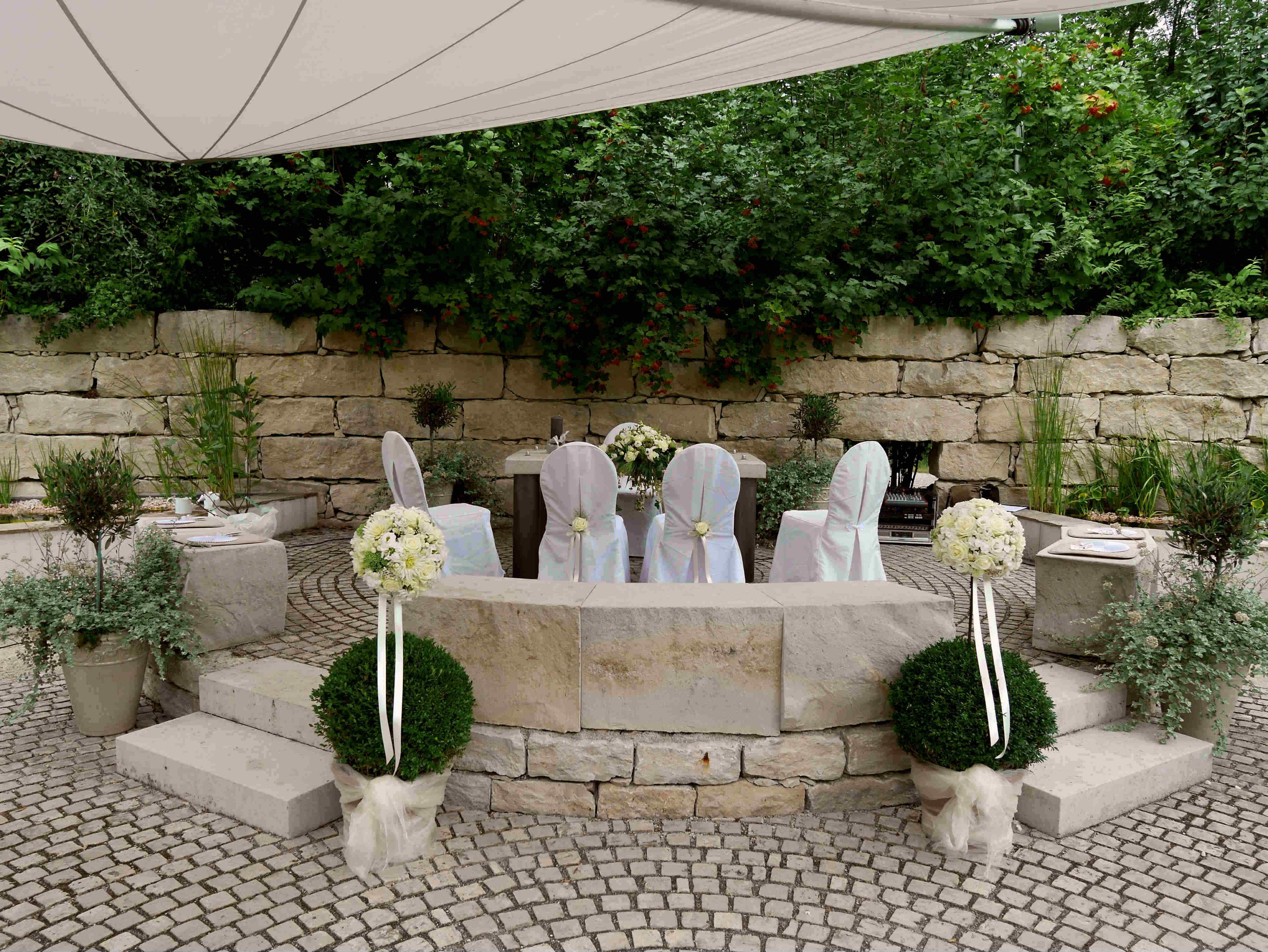 Wedding decoration in the garden with white chairs and flowers.