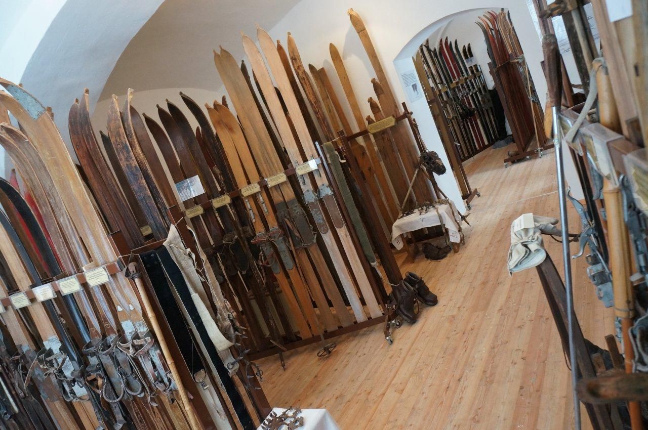 A room full of old wooden skis and ski equipment in a museum.