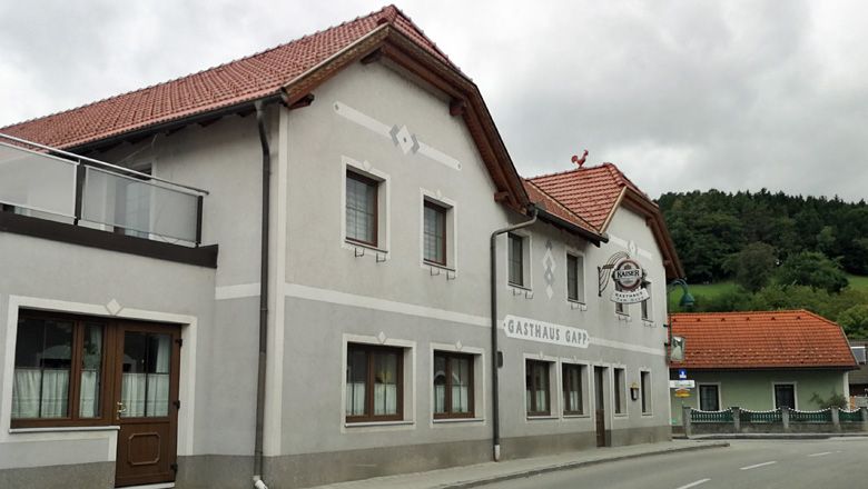 Gasthaus Gapp in Weinburg with gray façade and red roof.