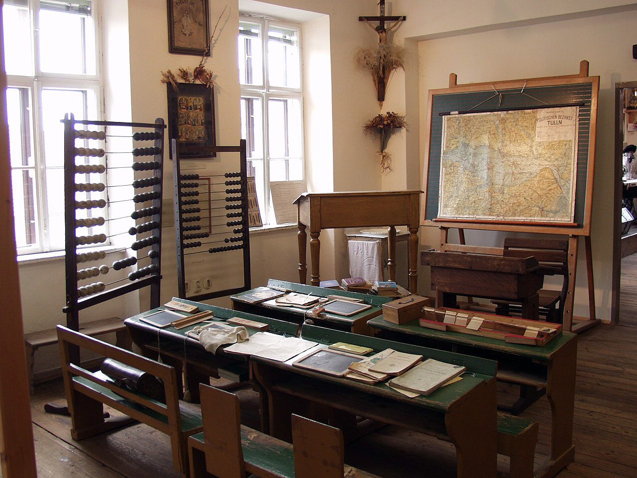Historical classroom with abacus, map and old school desks.