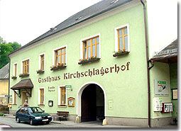 A traditional inn with a green façade and the inscription 'Gasthaus Kirschlagerhof'.